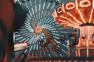 A lit swing ride at night with glowing lights symbolizes shared joy, movement, and emotional connection in groups.