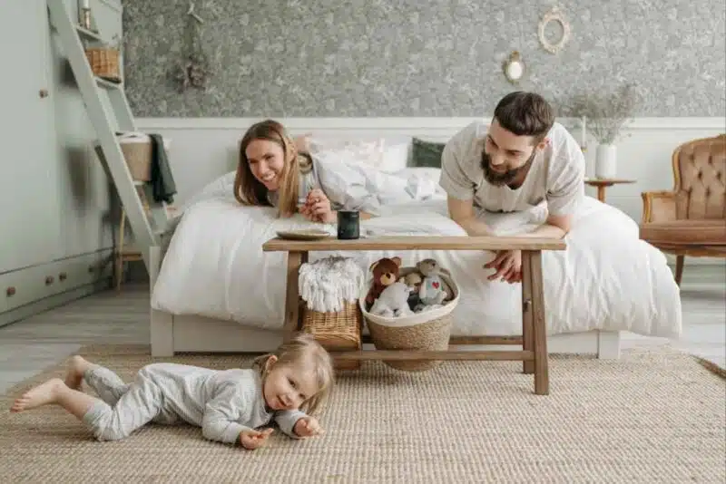 Young family bonding in a cozy bedroom, symbolizing support during major life transitions in Singapore