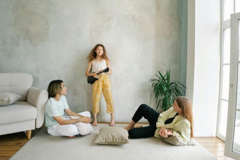 Child expressing creativity while parents listen attentively, illustrating emotional regulation and connection supported by parenting therapy.