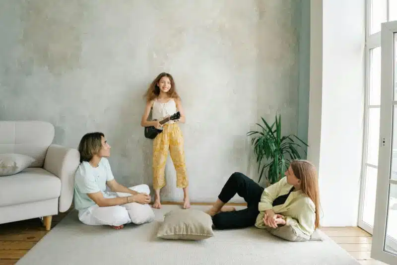 Child expressing creativity while parents listen attentively, illustrating emotional regulation and connection supported by parenting therapy.