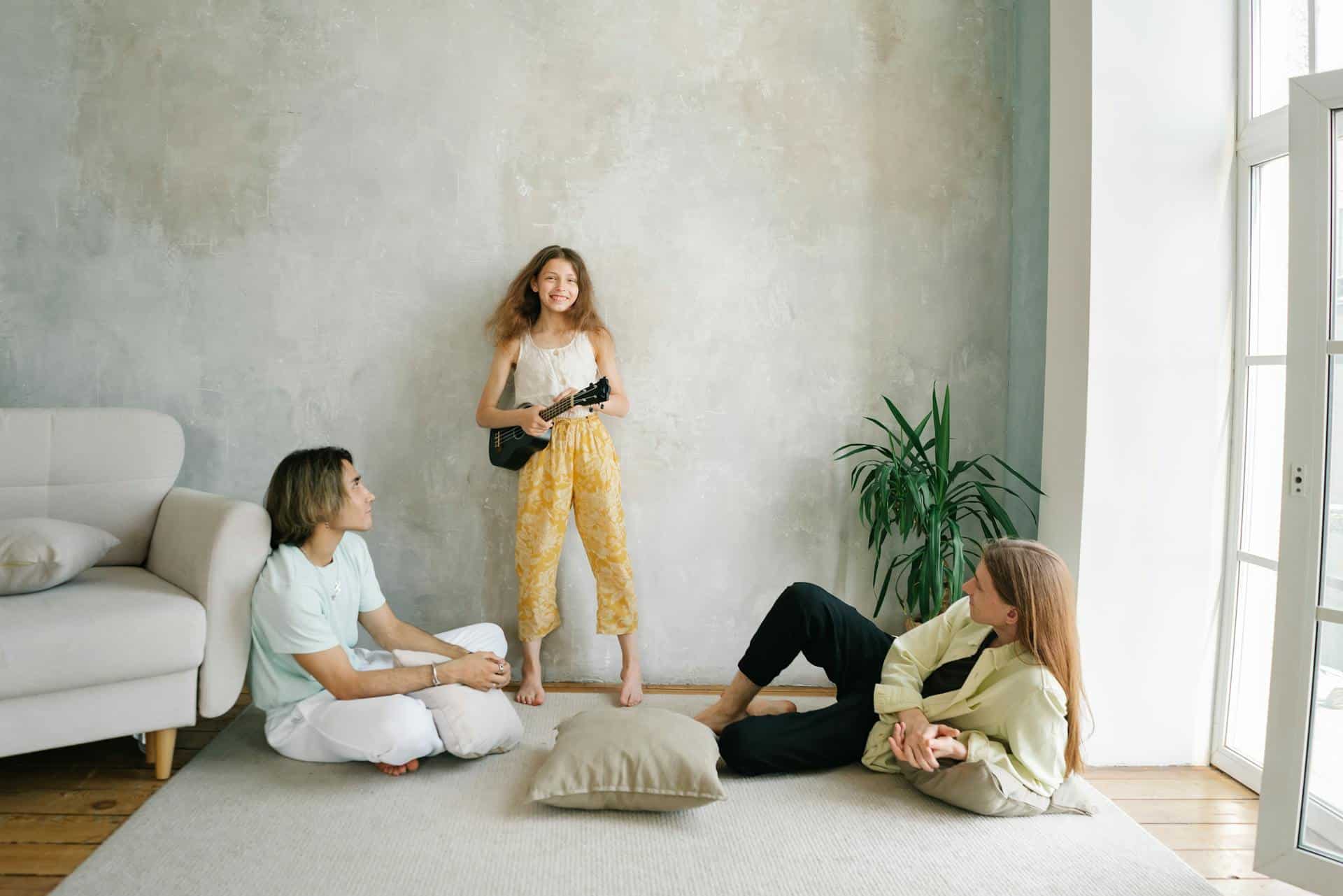 Child expressing creativity while parents listen attentively, illustrating emotional regulation and connection supported by parenting therapy.