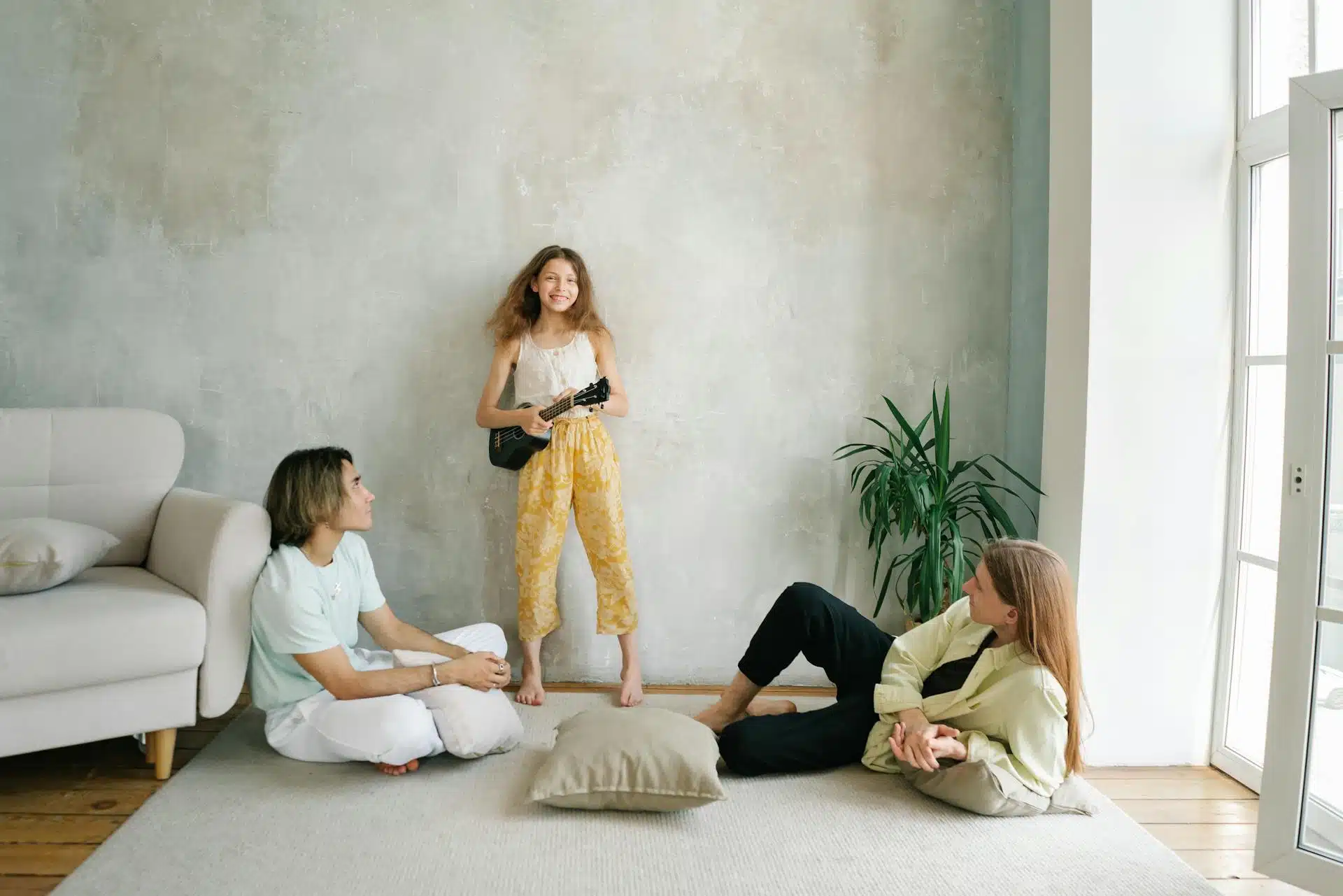 Child expressing creativity while parents listen attentively, illustrating emotional regulation and connection supported by parenting therapy.
