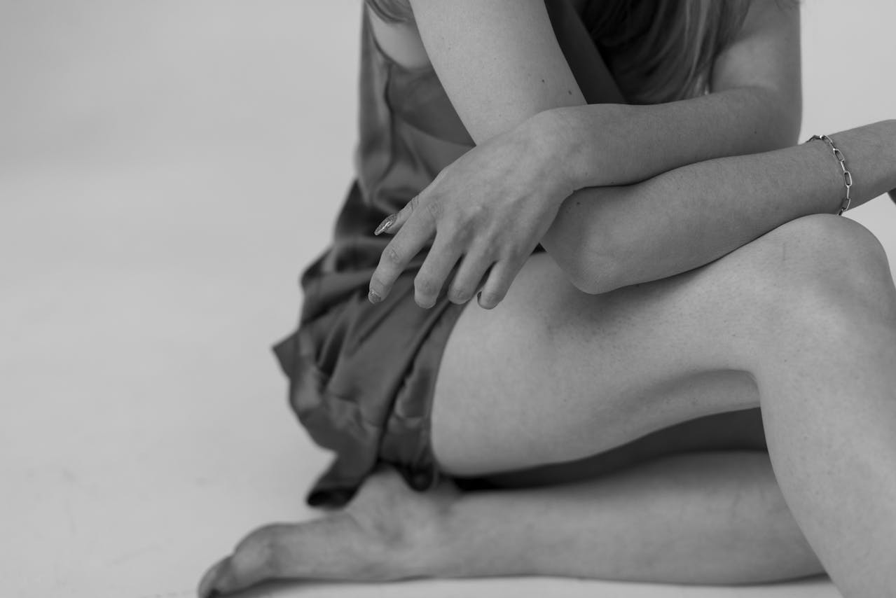 Person sitting with arms wrapped around themselves, reflecting emotional distress and existential crisis.