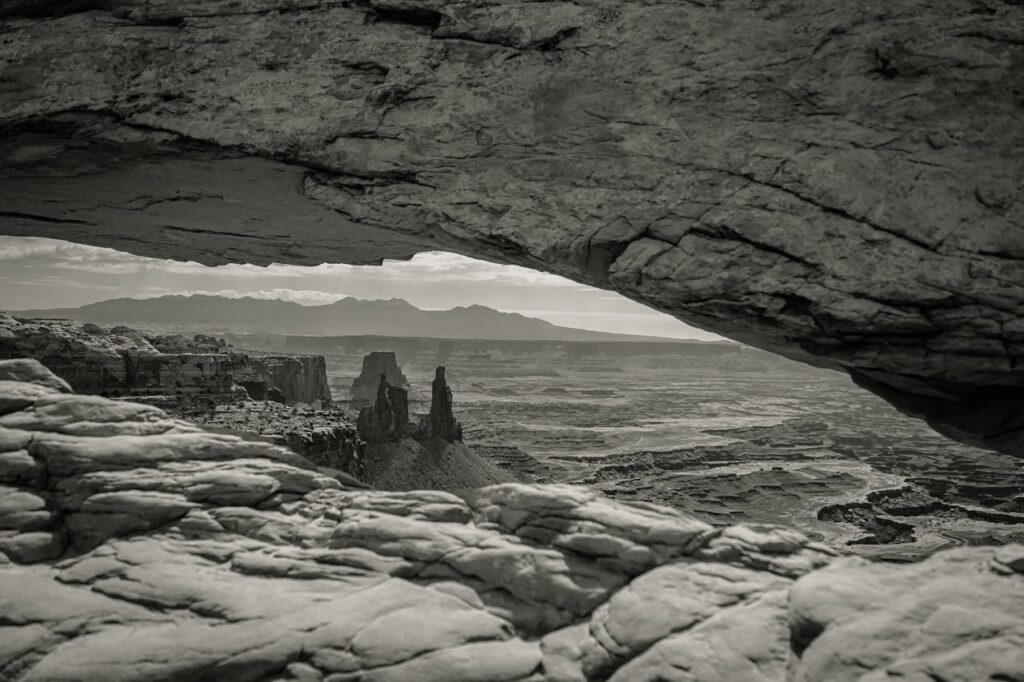 Rock arch framing a vast, empty landscape symbolizing the search for meaning during an existential crisis.