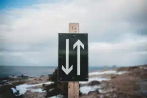 Mountain road sign pointing up and down symbolizing life direction, decisions, and the search for meaning and purpose