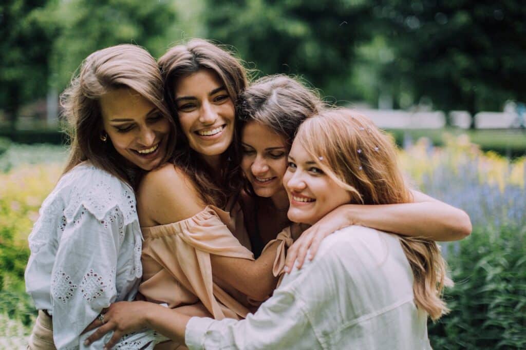 Group of women embracing outdoors, symbolizing emotional support and connection in group therapy