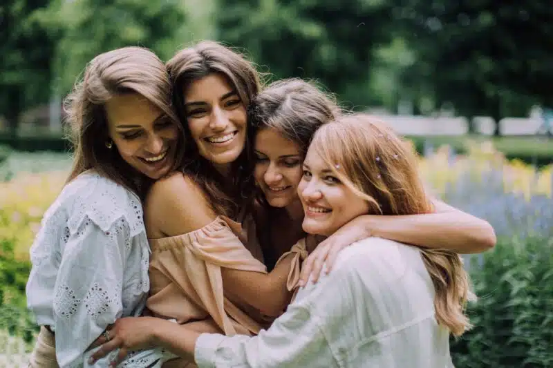 Group of women embracing outdoors, symbolizing emotional support and connection in group therapy