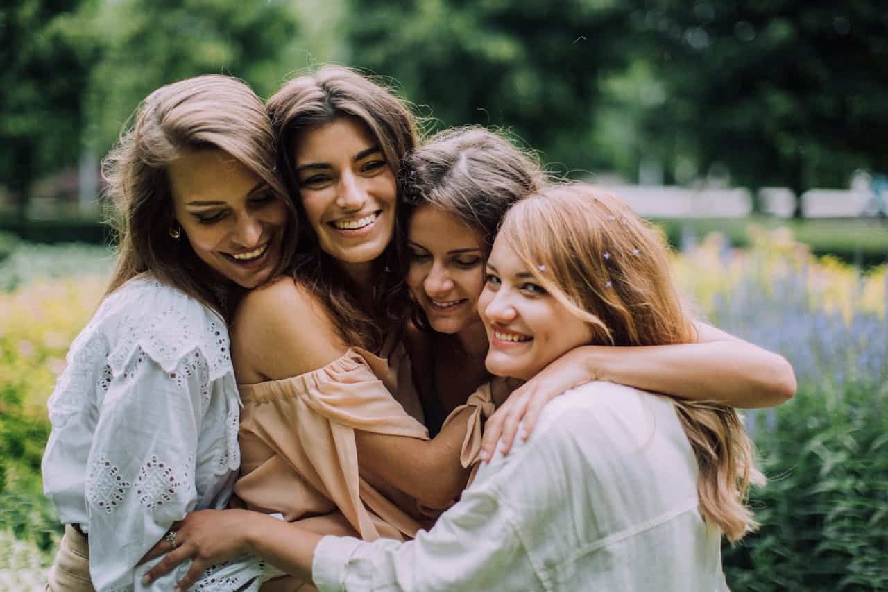 Group of women embracing outdoors, symbolizing emotional support and connection in group therapy