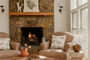 A cozy fireplace with two chairs and artwork, creating a warm, safe space for reflection and open conversation.