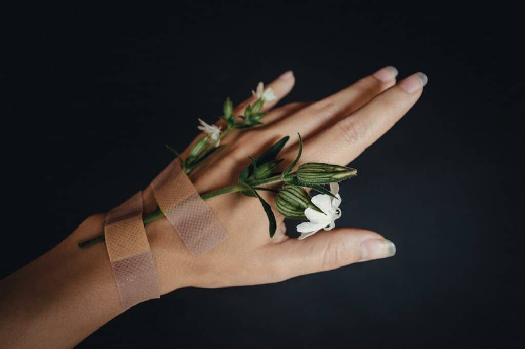 Close-up of hand holding a flower representing grounding techniques for anxiety relief