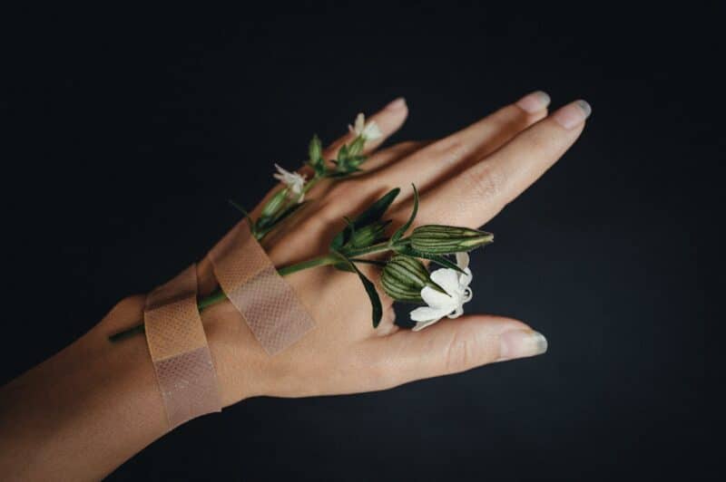 Close-up of hand holding a flower representing grounding techniques for anxiety relief