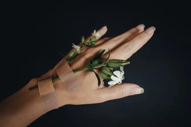 Close-up of hand holding a flower representing grounding techniques for anxiety relief