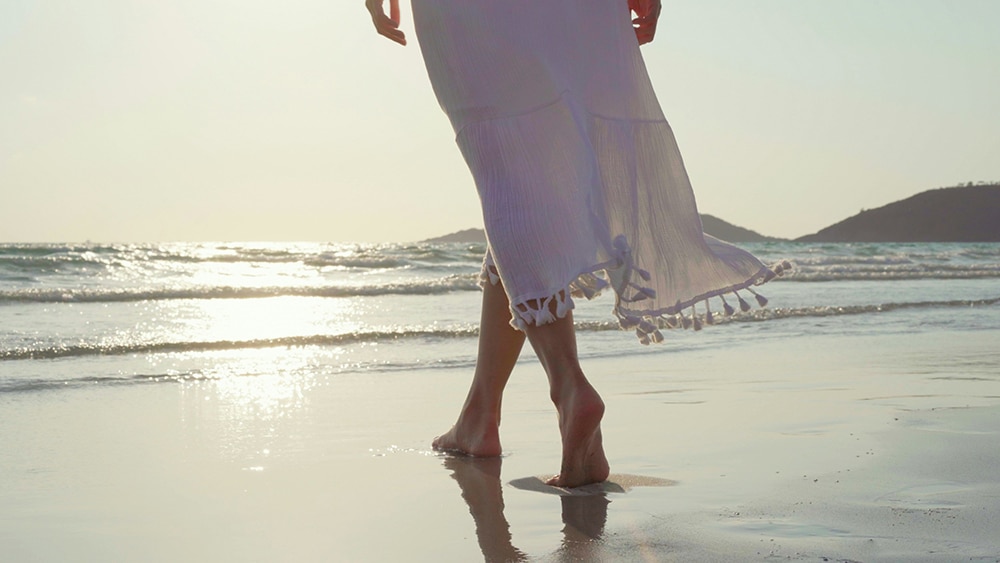 young Asian woman walking on beach