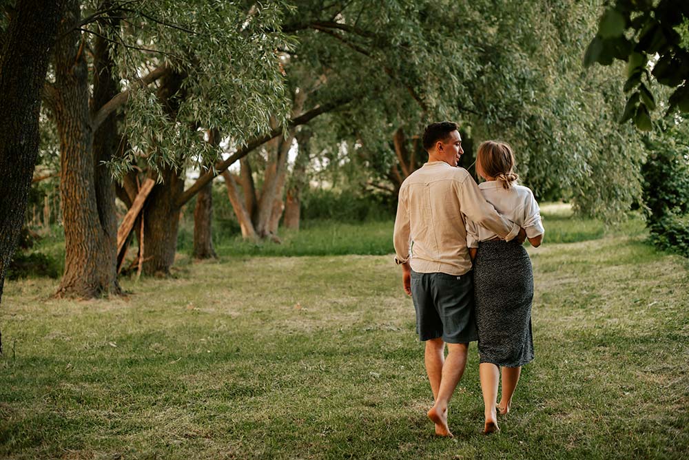 A man and a woman walking through a park.
